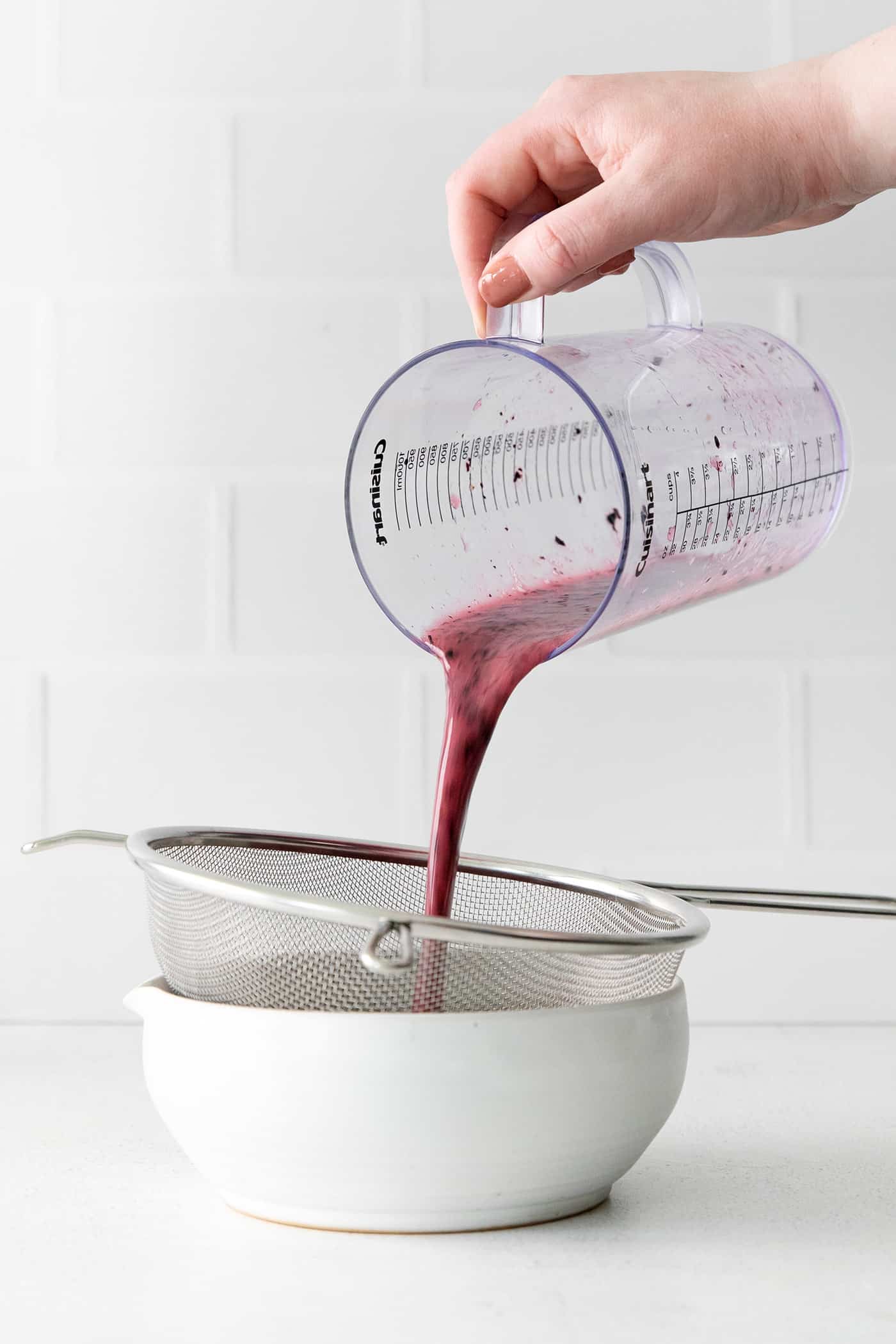 Blueberry juice being strained