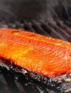 A salmon fillet cooking on the grill