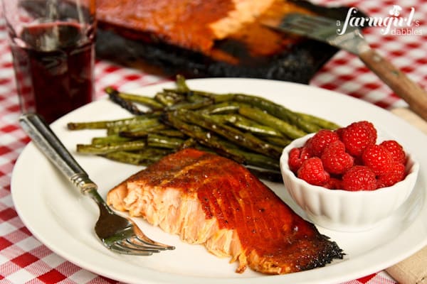 a plate with salmon, grilled asparagus, and raspberries