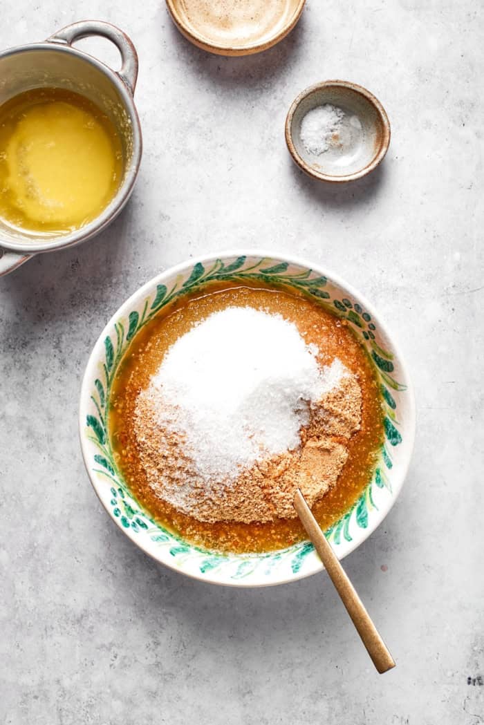 Overhead view of ingredients for graham cracker crust in bowl with spoon