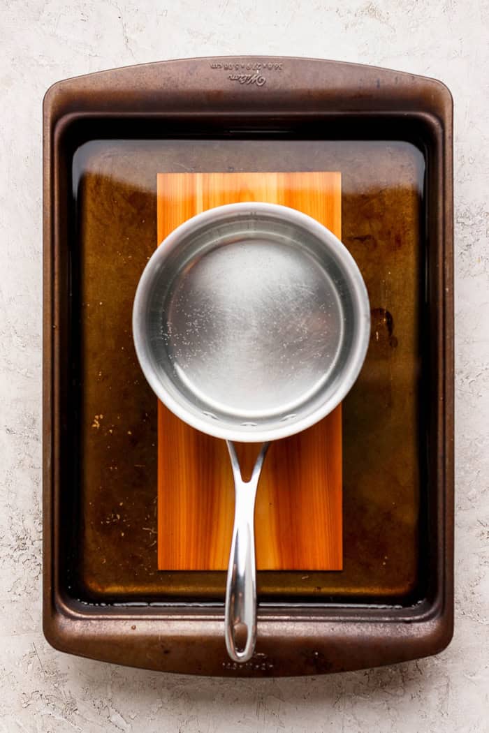 Pan set on top of cedar plank in tray of water