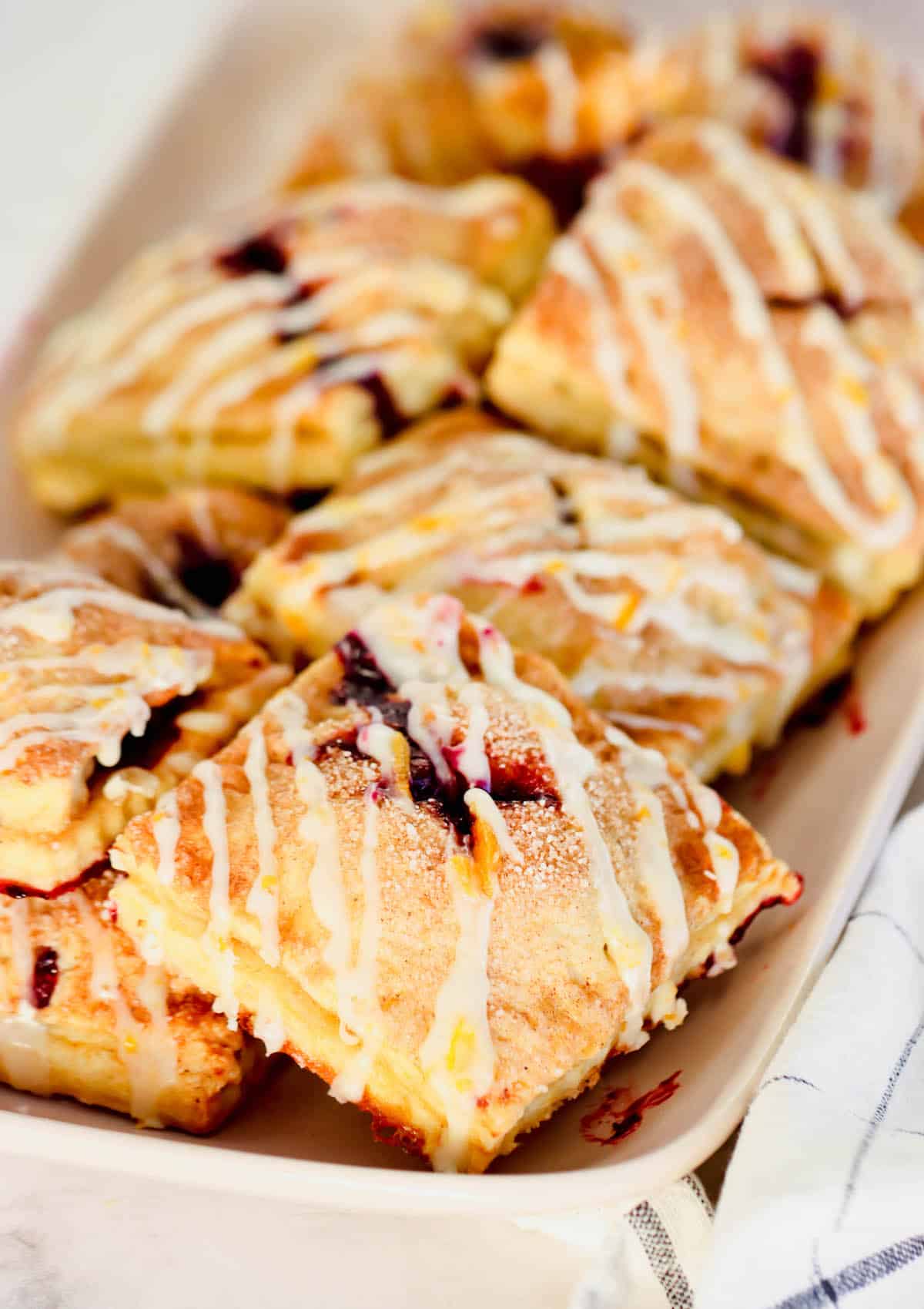 Several square blueberry hand pies drizzled with orange glaze