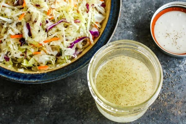 een potje azijn-koolsla dressing en een kom koolsalade