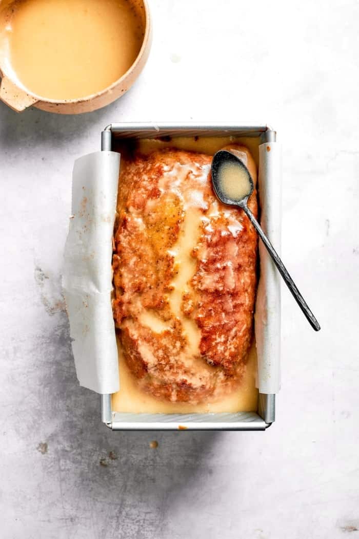 Loaf of almond lemon poppy seed bread topped with lemon glaze.