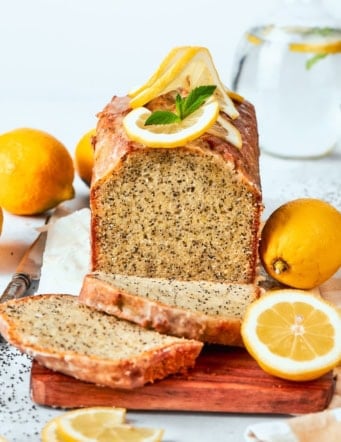 Loaf of almond lemon poppy seed bread with two slices cut.