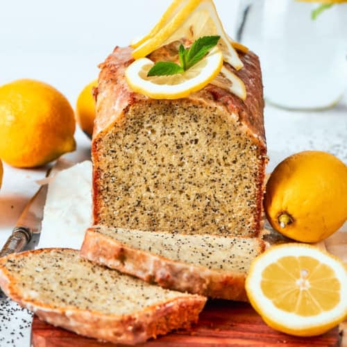 Loaf of almond lemon poppy seed bread with two slices cut.