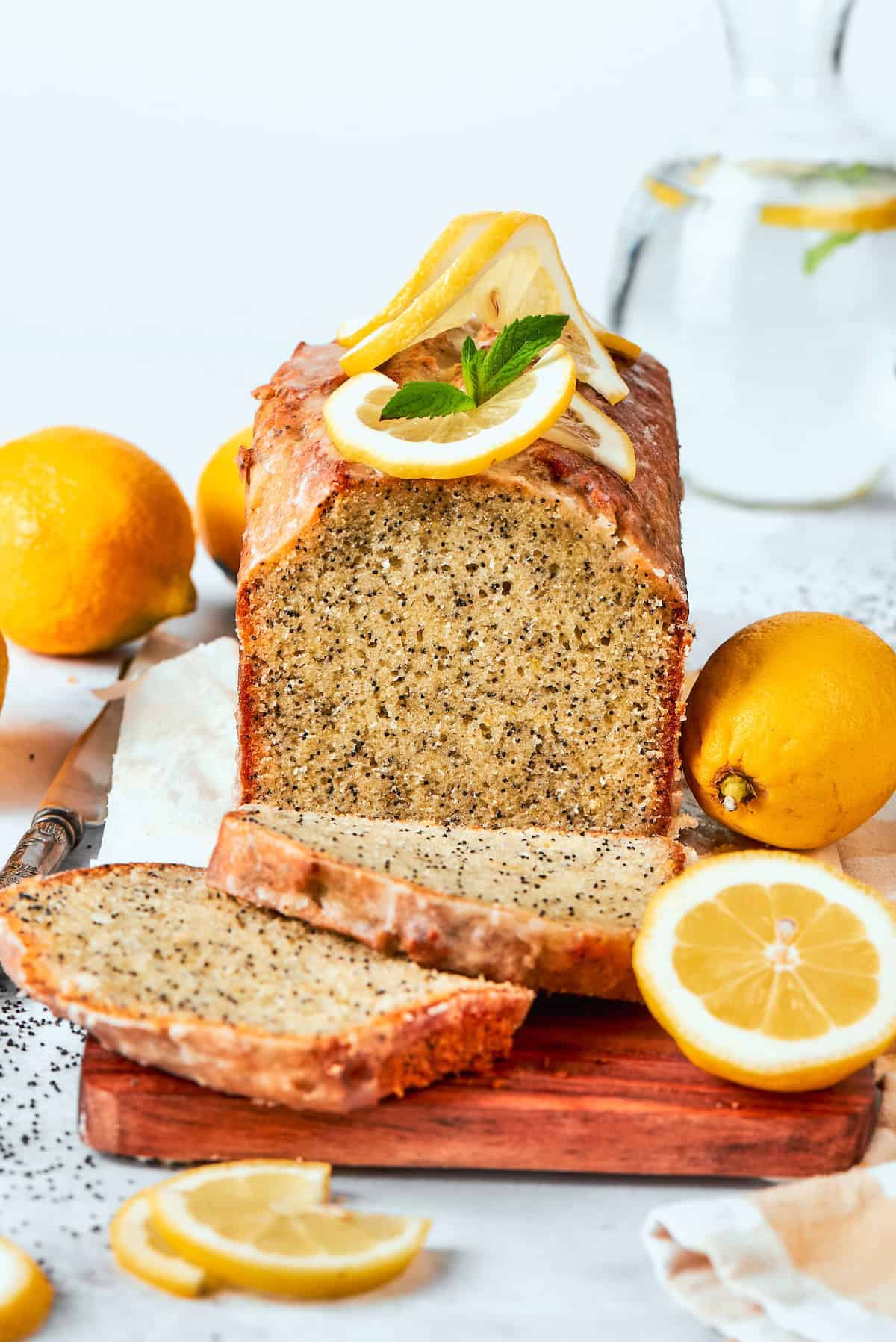 Loaf of almond lemon poppy seed bread with two slices cut.