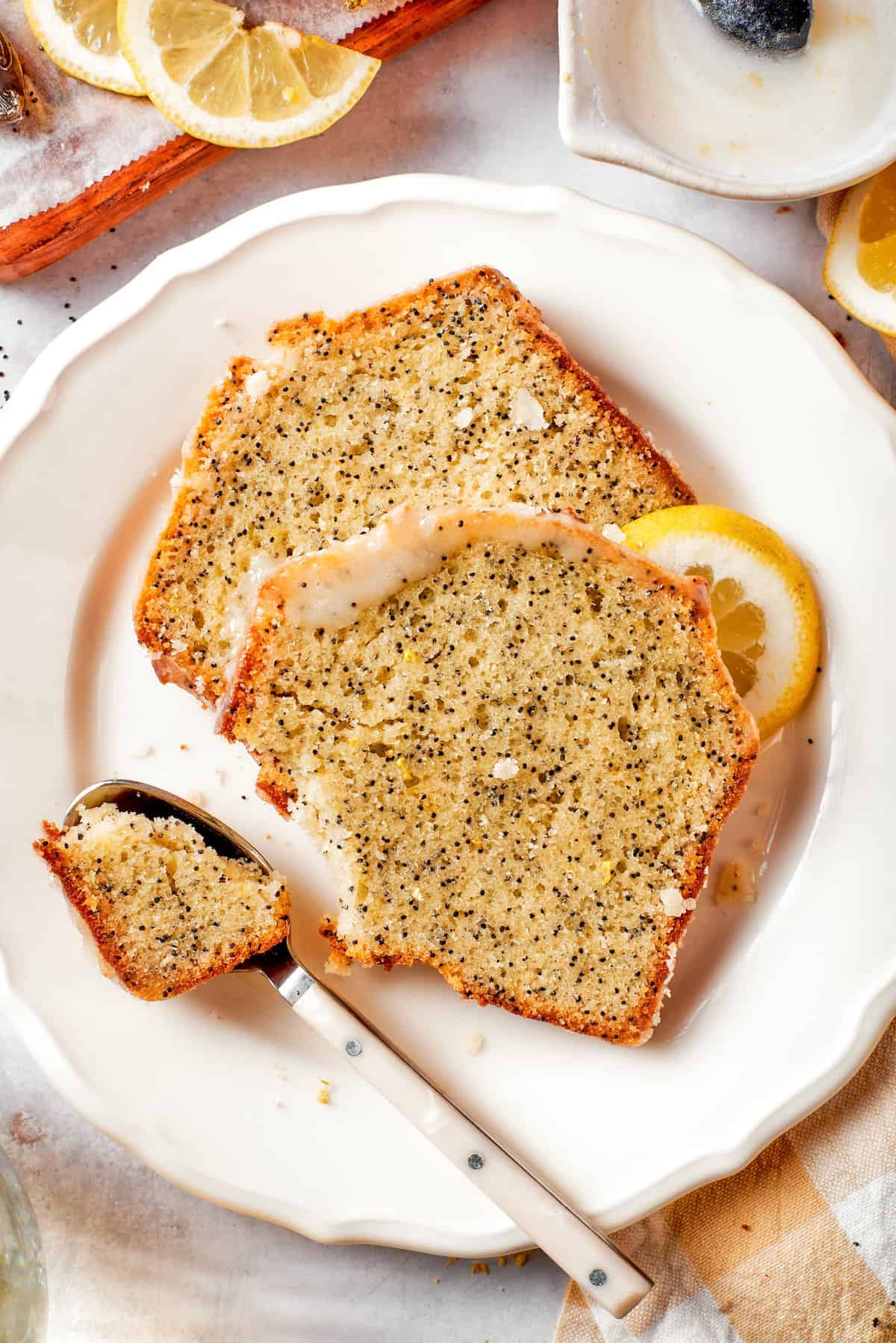 Spoonful of almond lemon poppy seed bread on plate with two slices.