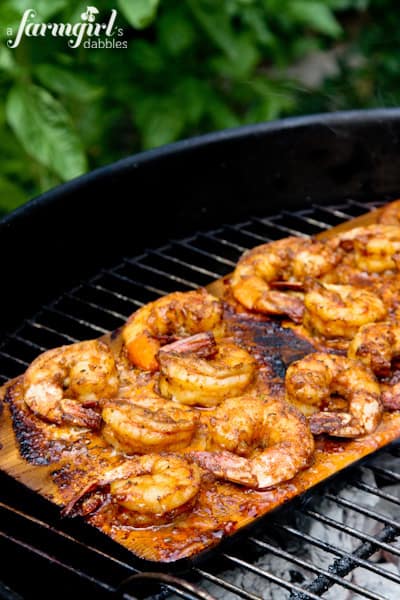 shrimp on a plank grilling on a charcoal grill