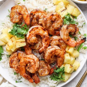 Overhead view of grilled jerk shrimp on plate with cilantro lime rice and pineapple