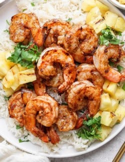 Overhead view of grilled jerk shrimp on plate with cilantro lime rice and pineapple