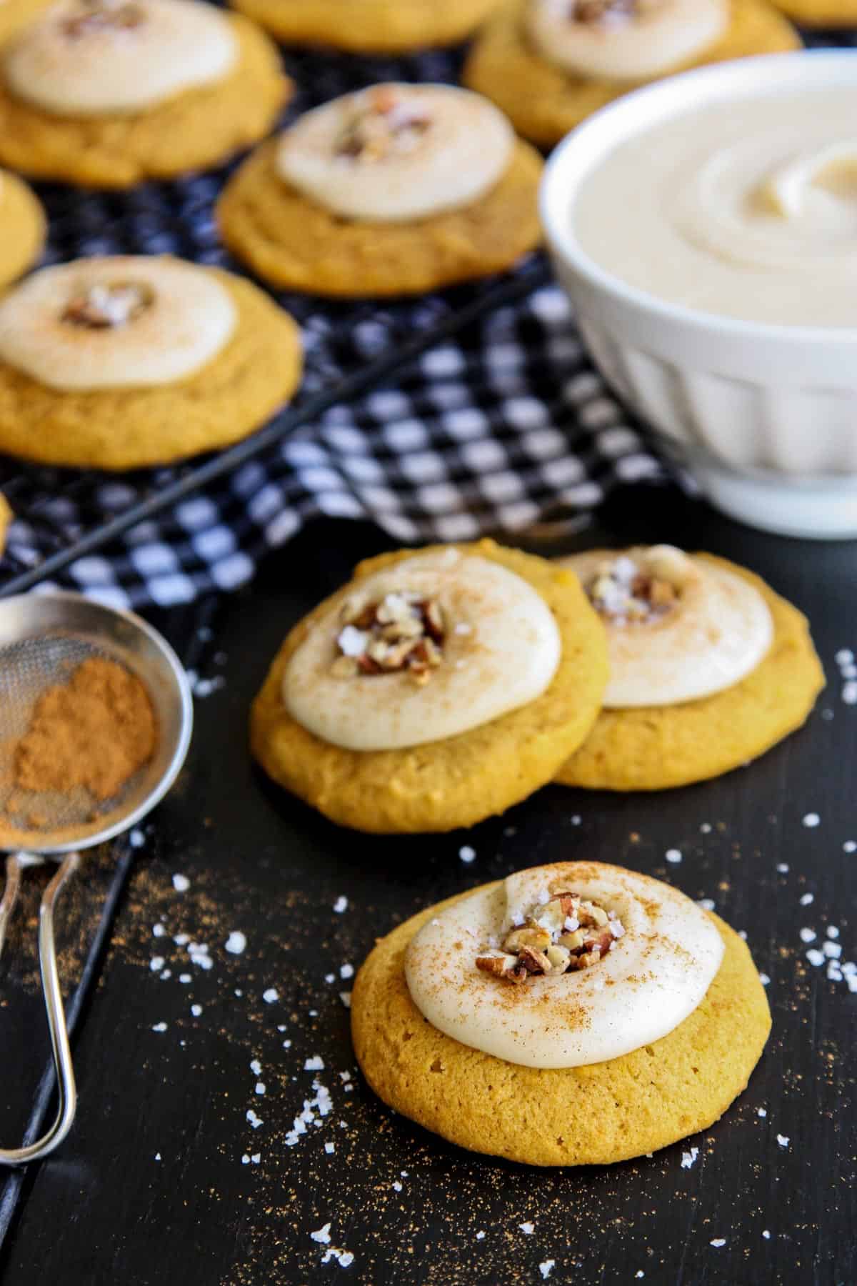 Melt-In-Your-Mouth Pumpkin Cookies with a bowl of frosting