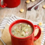 three red mugs of Clam Chowder with oyster crackers