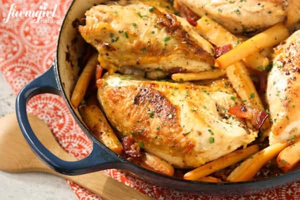 chicken breasts, hard cider, parsnips in a dark blue casserole dish