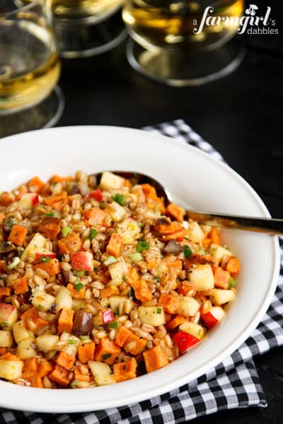 a bowl of Farro and Spiced Honey Salad with three glasses of white wine