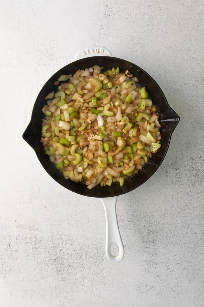 Onions and celery in a cast iron skillet