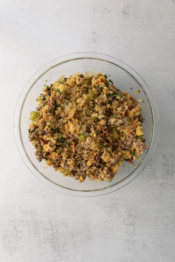 Cornbread stuffing with sausage and pecans mixed in a bowl