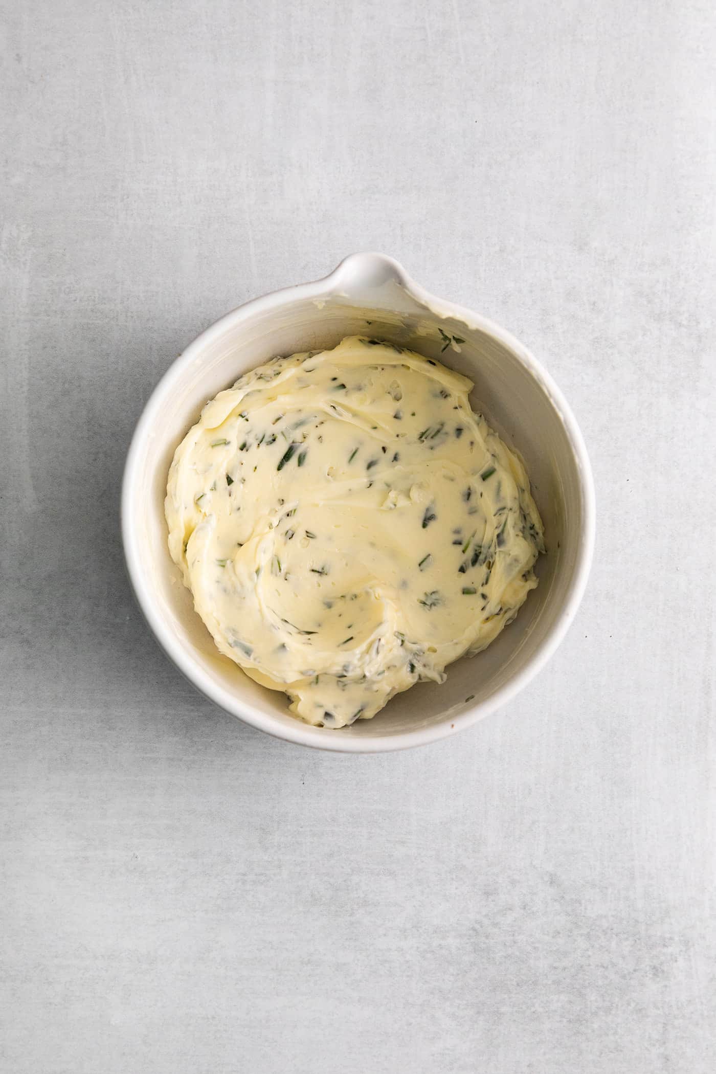 Herby compound butter in a white dish