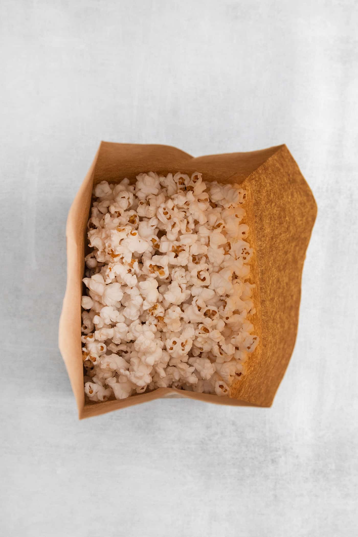 Popped popcorn in a brown paper bag
