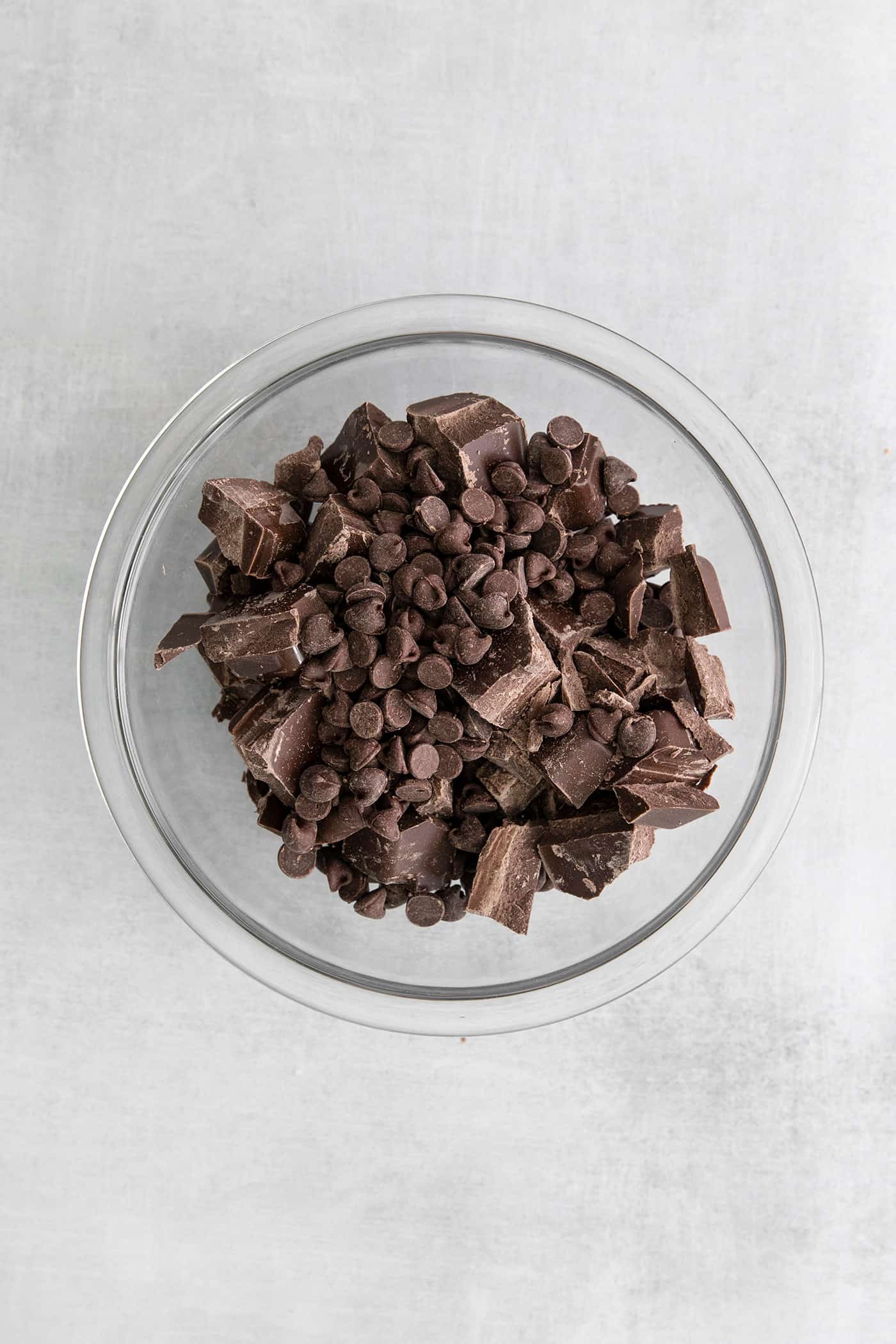 Chocolate chips and chocolate bark in a mixing bowl