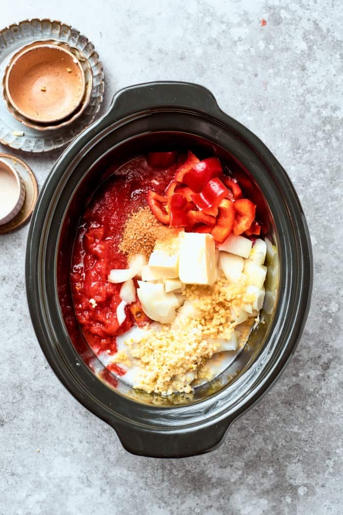 Overhead view of ingredients for beef curry added to crockpot