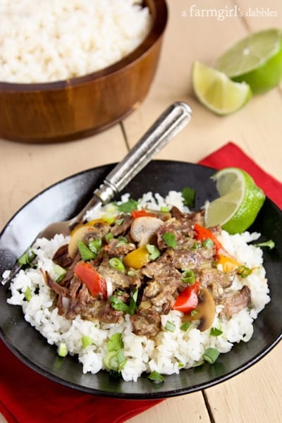 a black bowl of rice and topped with Coconut Curry Beef