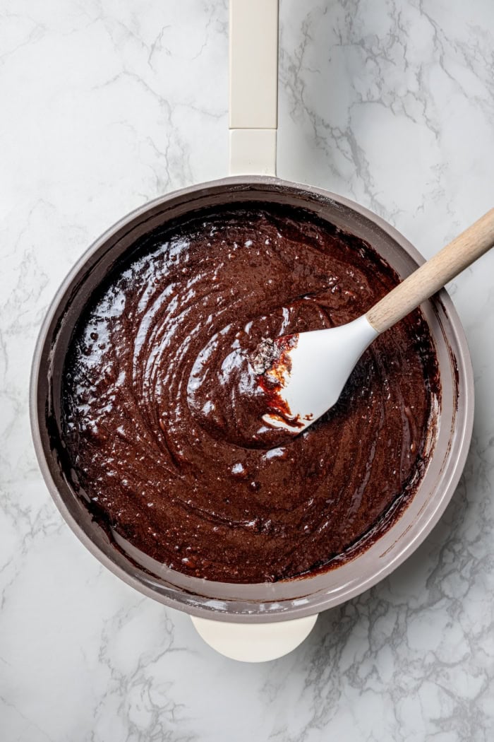Stirring brownie batter in pan.