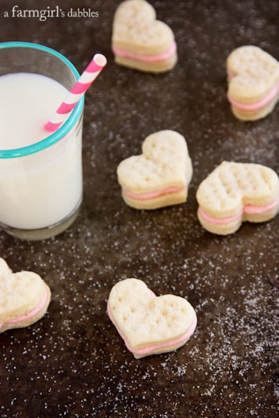 strawberry sandwich cookies with a glass of milk