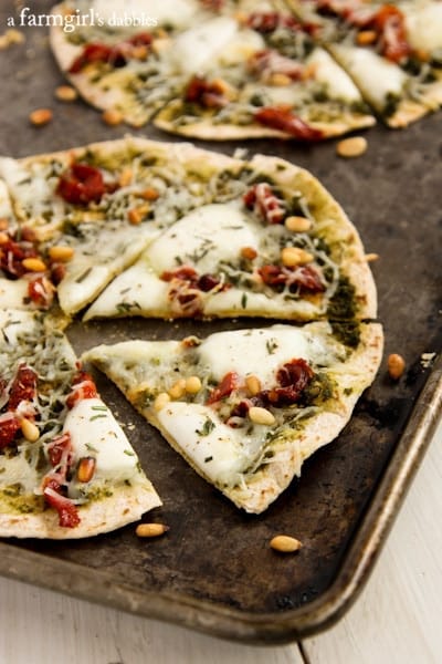 Tortilla Caprese Pizzas sliced and placed on a rimmed baking sheet