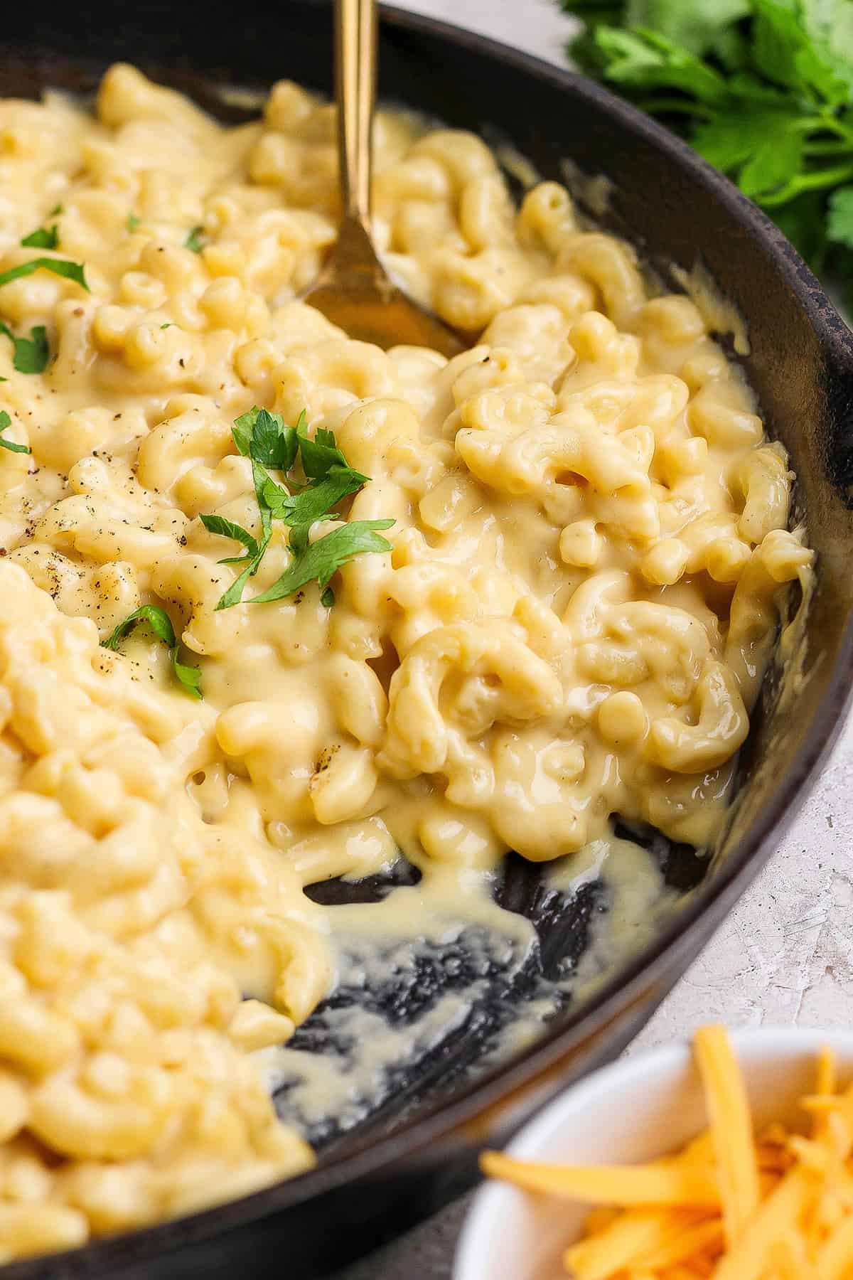 This homemade stovetop macaroni and cheese recipe is perfect for a weeknight! Ultra creamy, rich, and much quicker than the baked version. Spoon in pan of homemade macaroni and cheese.
