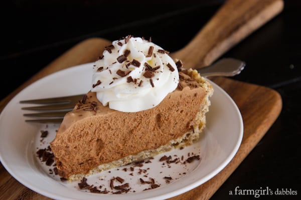 Chocolate French Silk Pie with Salted Pecan Crust on a white plate with a fork