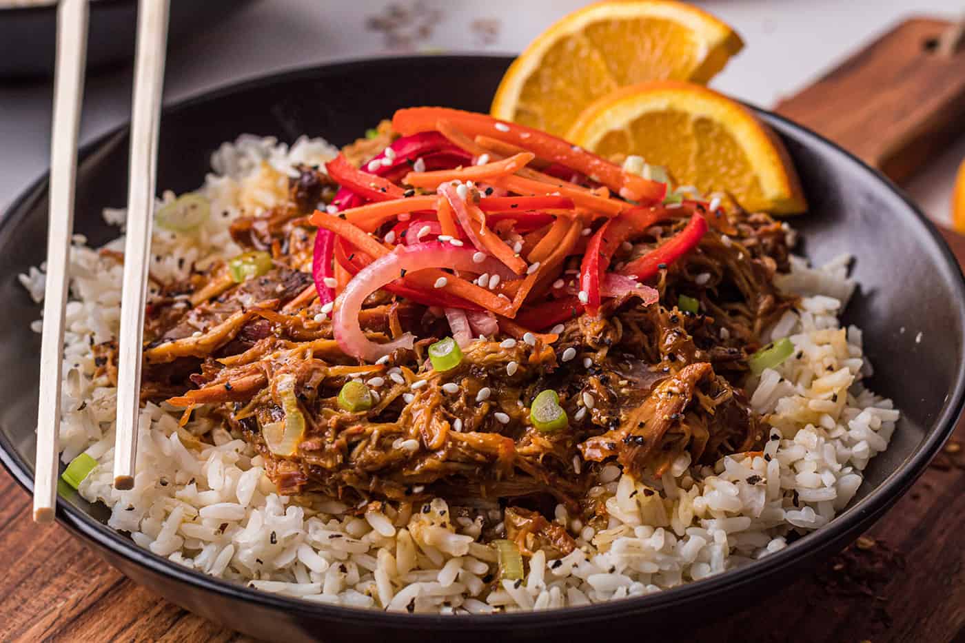 A black bowl of crockpot orange chicken