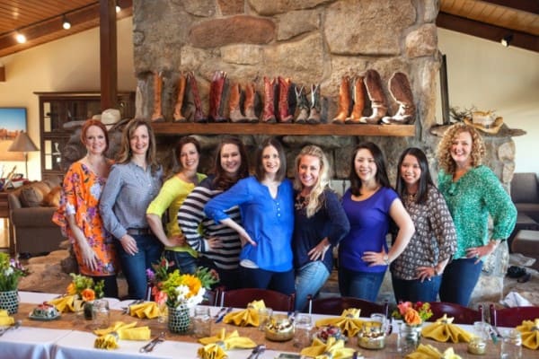 a group of women standing in front of a fireplace