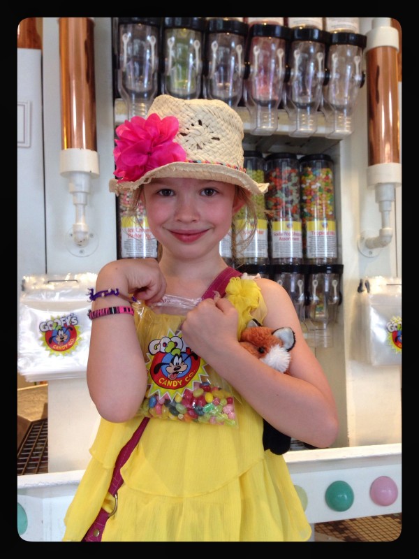 a young girl in a yellow dress at a candy store