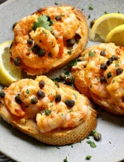 Three sriracha shrimp toasts on a gray plate