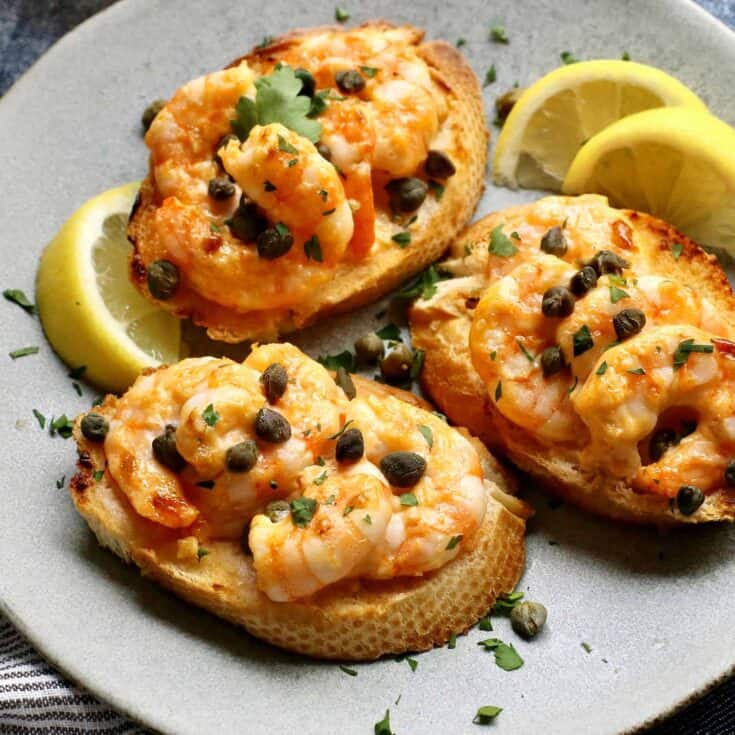 Three sriracha shrimp toasts on a gray plate