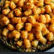pinterest image of tater tot hotdish in a cast iron skillet