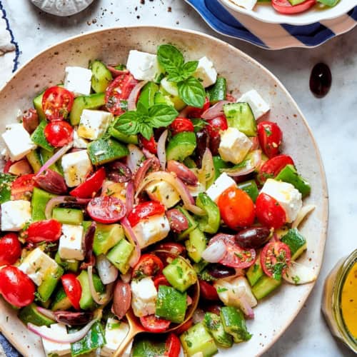 Overhead view of chopped greek Salad in bowl with spoon