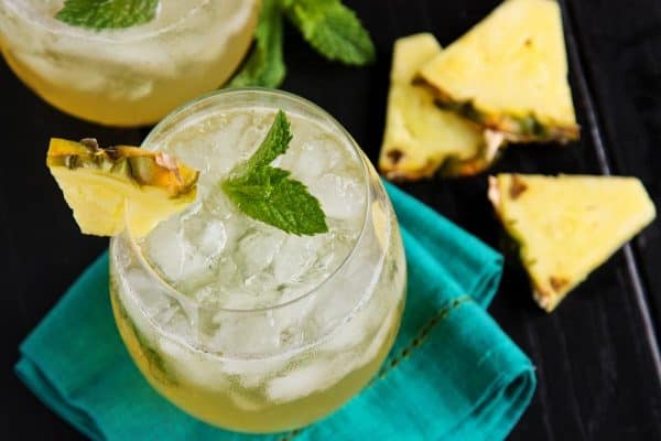 a glass of pineapple mint julep sangria with fresh pineapple slices