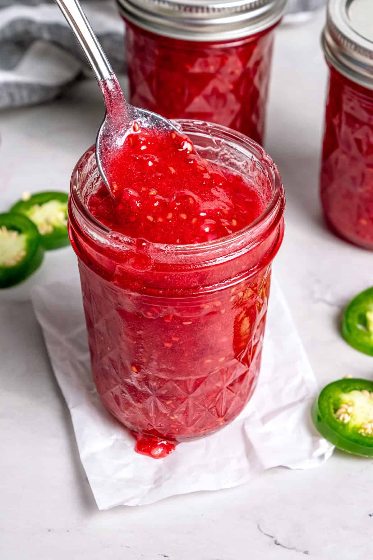 Jar of raspberry freezer jam with jalapeños