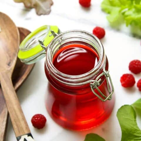 a clear jar of raspberry vinegar