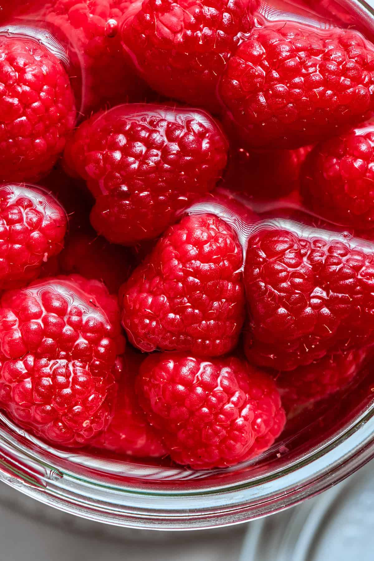 Made with just 3 simple ingredients, this homemade raspberry vinegar recipe is incredibly easy and fantastic for dressings, drinks and more! Raspberries in jar of vinegar.