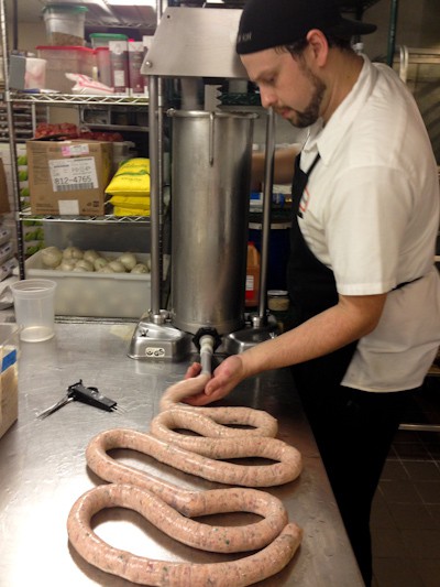 cheddarwurst coming out of a sausage machine