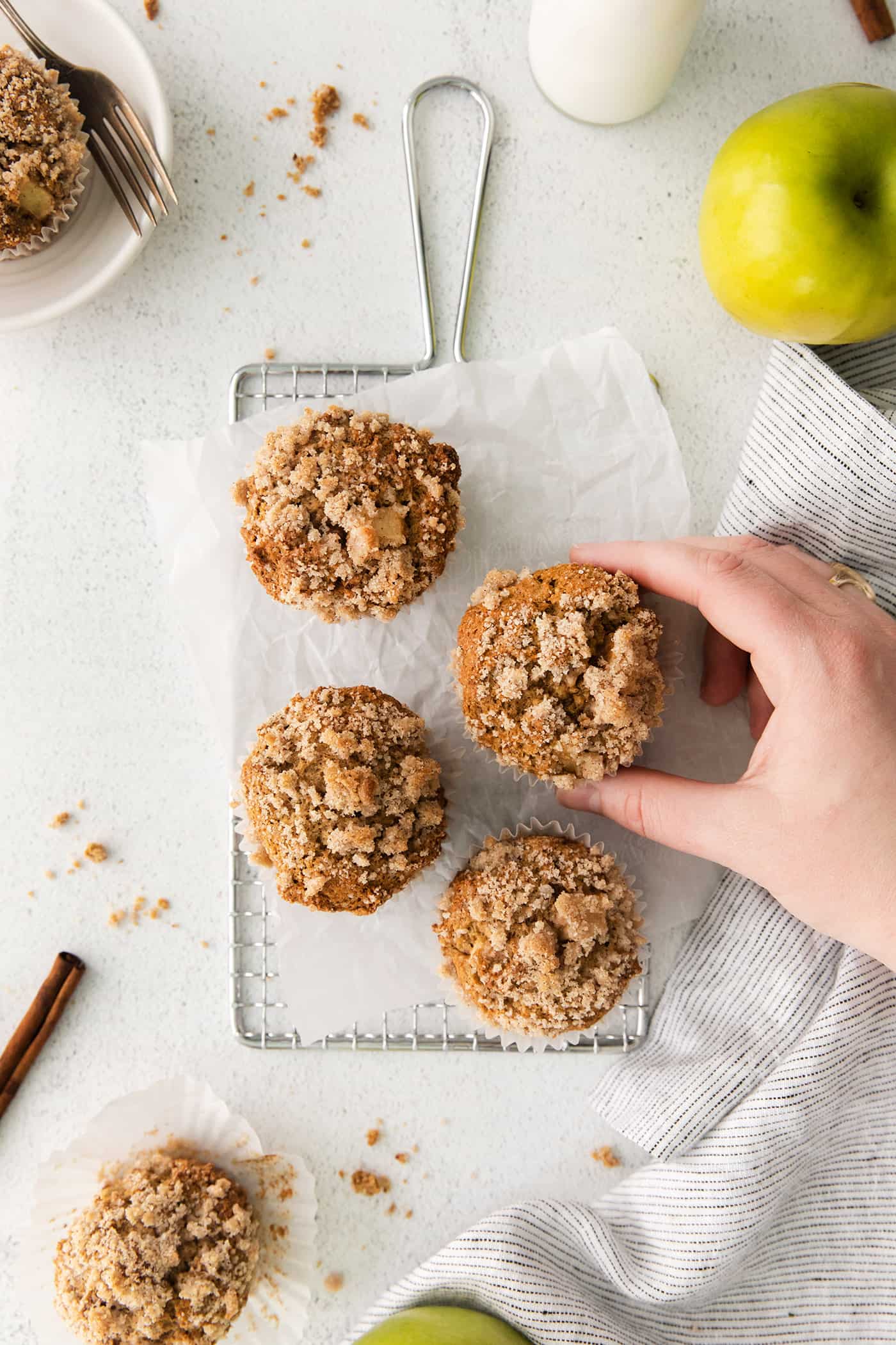A hand reaching for an apple muffin