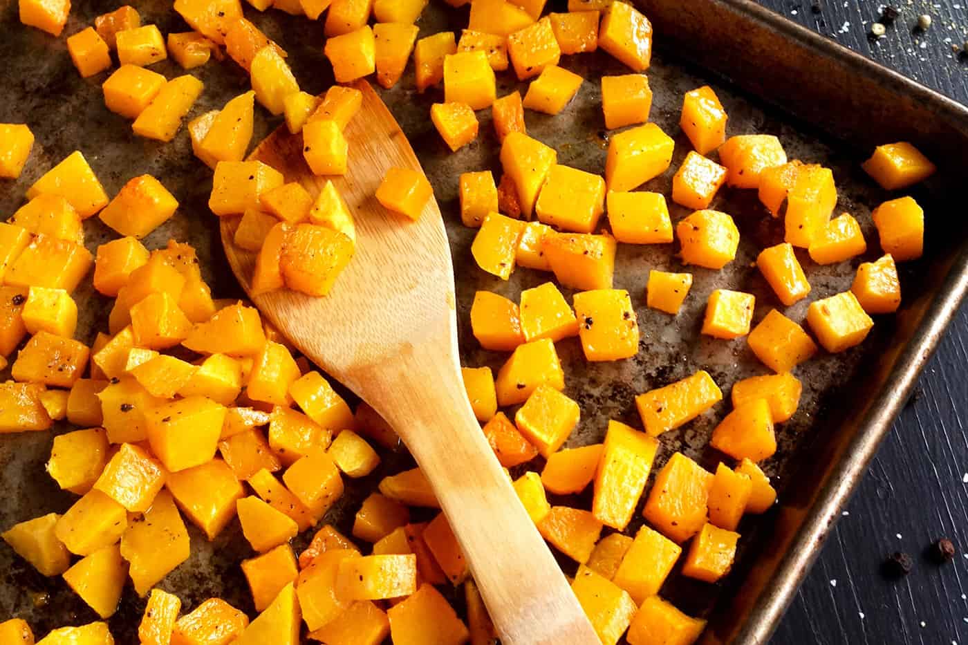 Roasted butternut squash cubes on a sheet pan