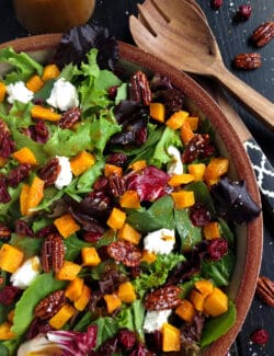 Harvest salad with butternut squash in a wooden bowl