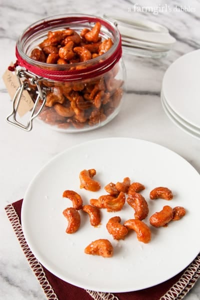 Candied Sriracha Cashews on a white plate and in a glass jar