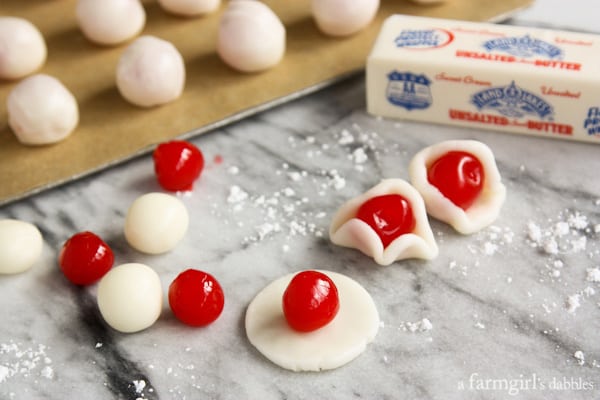 cherries being wrapped in a fondant dough