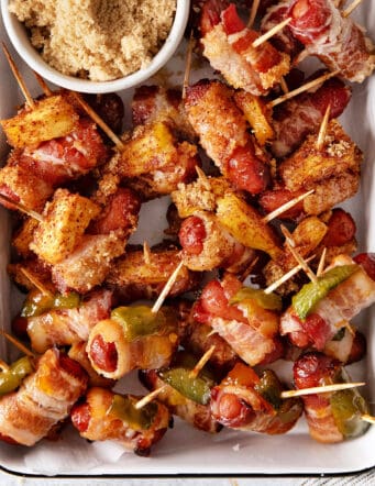 Bacon wrapped smokies with pineapple and jalapeno on a baking sheet