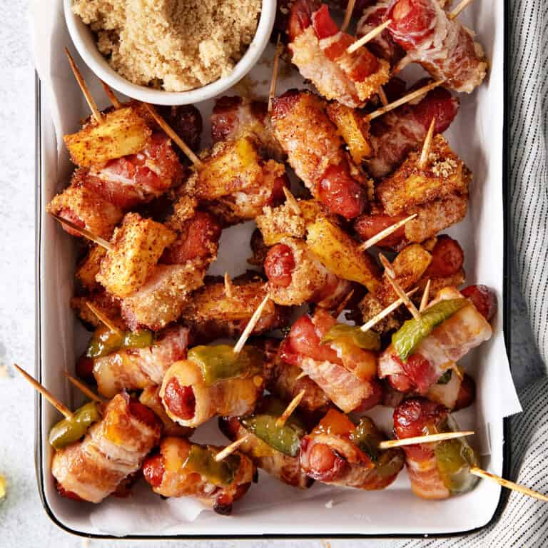 Bacon wrapped smokies with pineapple and jalapeno on a baking sheet